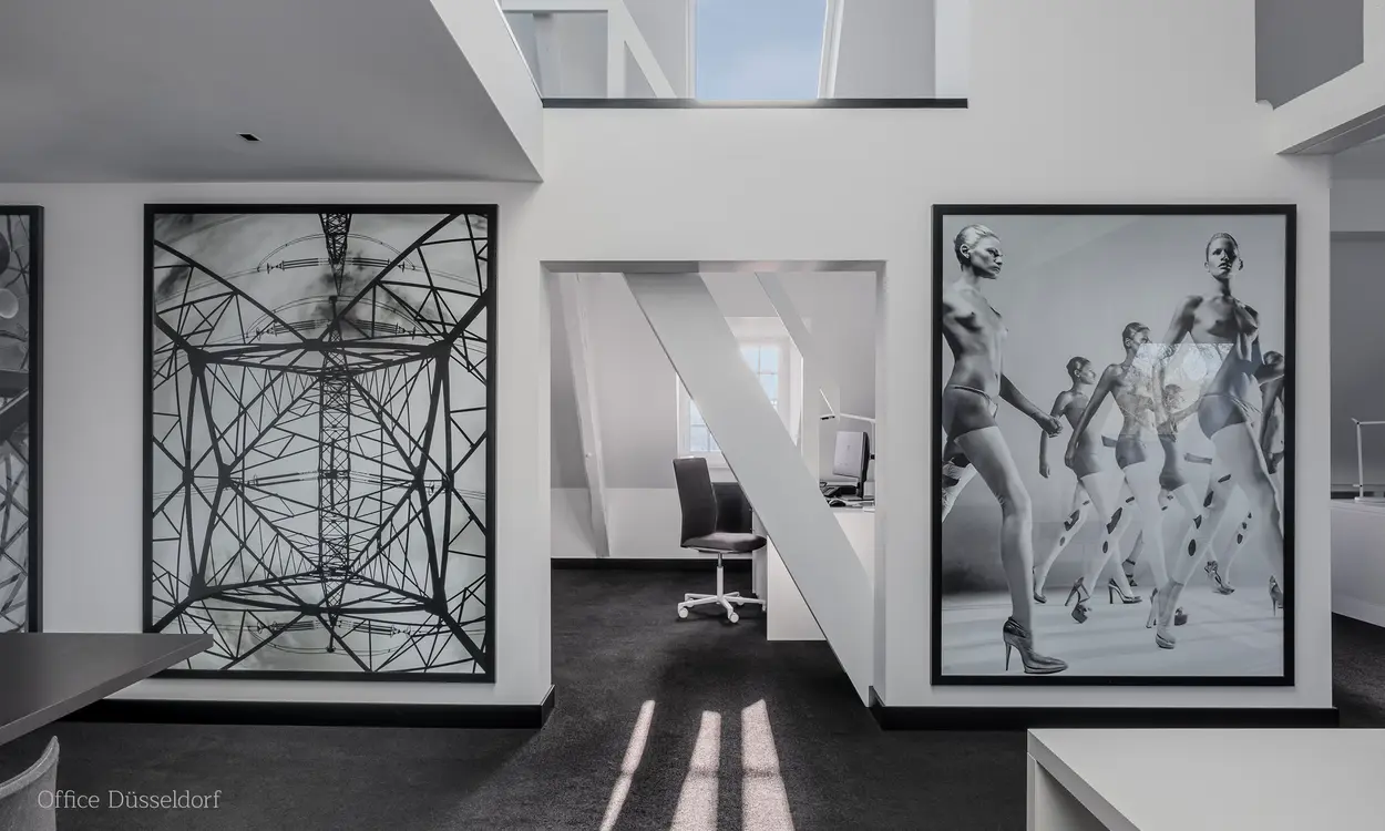 Außenansicht des Gebäudes 'Happy Franky' mit begrünten Fassadenelementen, großem Logo und moderner Architektur, umgeben von parkenden Autos.
