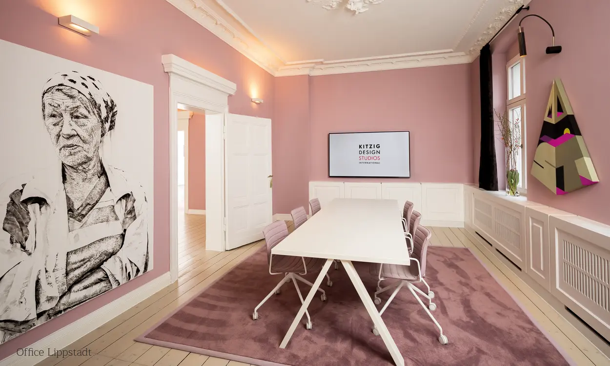 Gebäude 'Happy Franky' bei Nacht mit beleuchtetem Logo und Schriftzug, moderner Architektur und begrünten Fassaden.