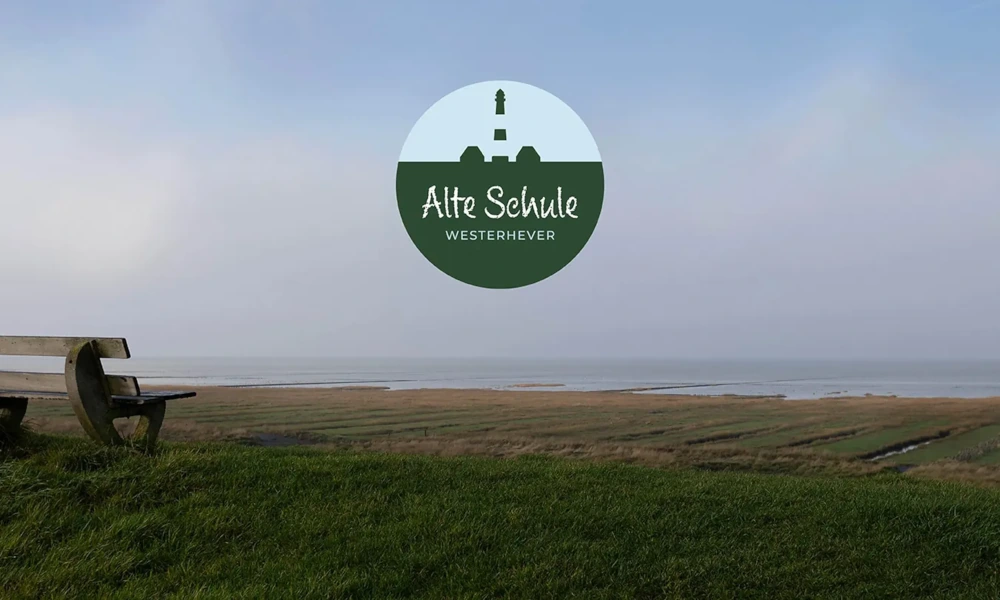 Logo der 'Alte Schule Westerhever' vor einer weiten Landschaft mit Wiese, Deich und Meerblick.