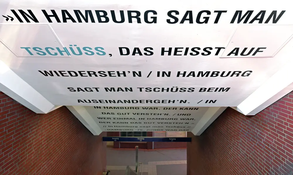 Modern eingerichtetes Schlafzimmer mit zwei Einzelbetten, stilvoller Wandbeleuchtung, rundem Teppich und minimalistischen Designelementen.