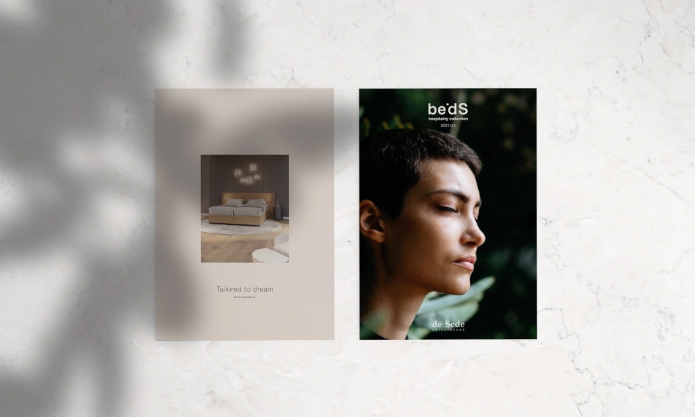 Zwei Broschüren der Marke 'beDS', links mit dem Titel 'Tailored to dream' und einem Bett, rechts mit dem Portrait einer entspannten Frau vor natürlichem Hintergrund.
