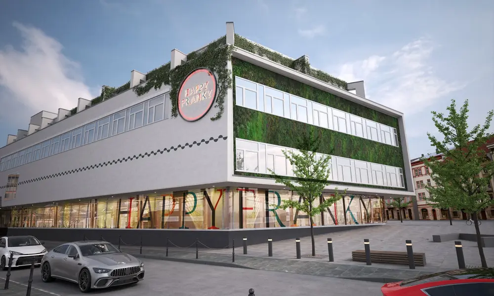 Außenansicht des Gebäudes 'Happy Franky' mit begrünten Fassadenelementen, großem Logo und moderner Architektur, umgeben von parkenden Autos.