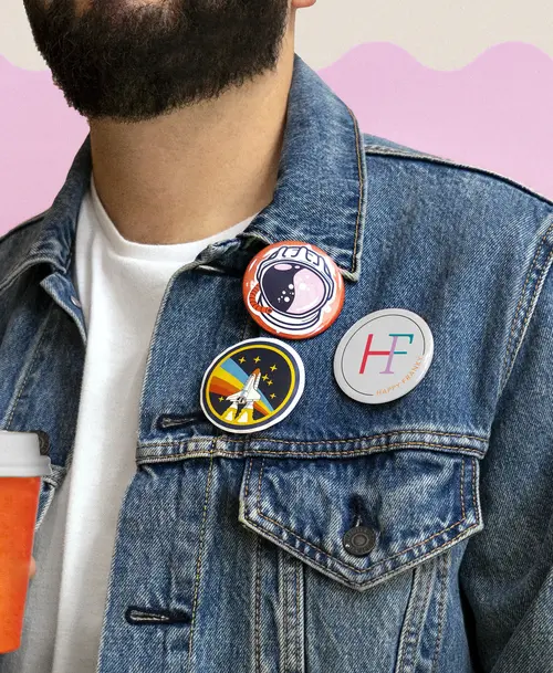 Person mit Jeansjacke, dekoriert mit Pins, darunter ein 'Happy Franky'-Logo.