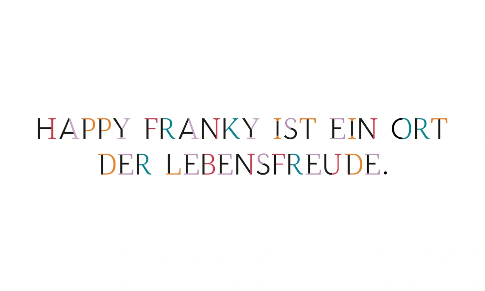 Schriftzug 'Happy Franky ist ein Ort der Lebensfreude' in bunten Buchstaben auf weißem Hintergrund.