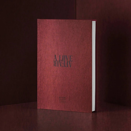 Buch mit dunkelrotem Einband und dem auf dem Kopf stehenden Titel "A LOVE AFFAIR", stilvoll inszeniert vor einem passenden dunkelroten Hintergrund.