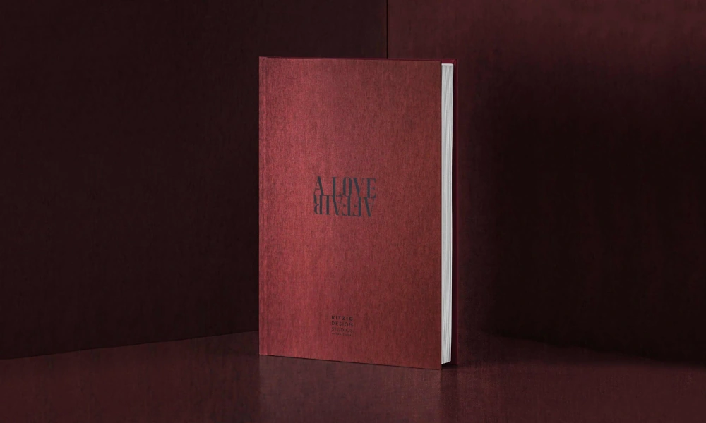 Ein rotes Hardcover-Buch steht aufrecht vor einem dunkelroten Hintergrund.
