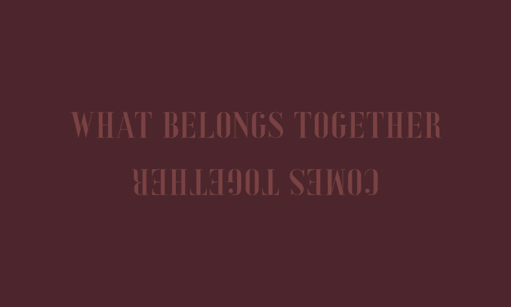 Dunkelroter Hintergrund mit dem spiegelverkehrten Schriftzug „WHAT BELONGS TOGETHER COMES TOGETHER“.