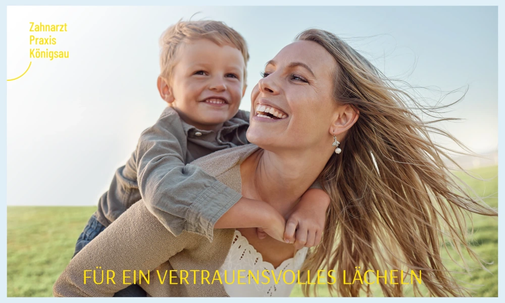 Lächelnde Frau mit Kind auf dem Rücken in einer grünen Landschaft, mit dem Text 'Für ein vertrauensvolles Lächeln' und dem Logo der Zahnarztpraxis Königsau.