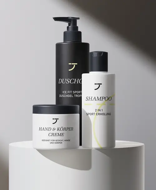 Pflegeprodukte der Marke „Turnhalle – Die Fitnesslounge“, darunter Duschgel, Shampoo und Hand- & Körpercreme in modernem Schwarz-Weiß-Design.