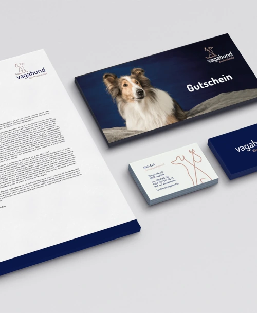 Corporate-Design-Elemente für das Hundehotel „Vagabund“, darunter Briefpapier, ein Gutschein, Visitenkarten und eine blaue Box mit Logo.