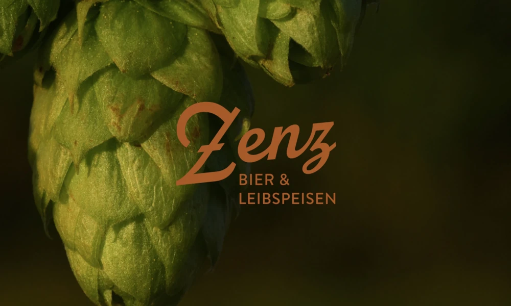 Logo des Zenz Wirtshauses vor Hopfendolde im Nahaufnahme-Stil – rustikales Branding mit Fokus auf Bierkultur und traditionellen Leibspeisen aus Mainz.